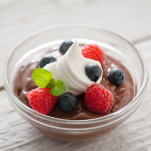 chocolate pudding with berries and cream in a bowl