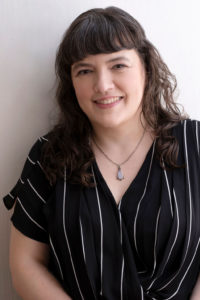 woman in a black and white stripped shirt smiling