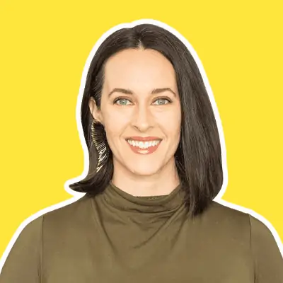 photo of a woman smiling at the camera with a bright yellow background