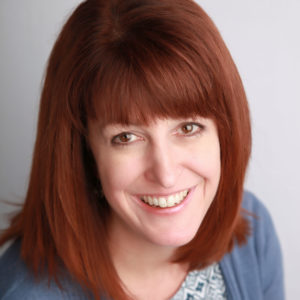 close up of a woman with red hair and blue cardigan