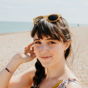 Close up of woman at the beach with sunglasses on her head and braided hair
