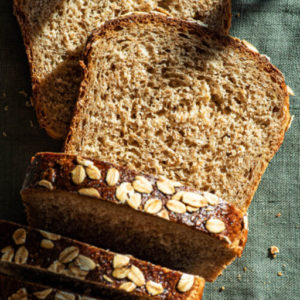 slices of bread with oats on top sitting on a green linen