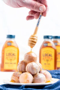 honey being dripped on top of donut balls