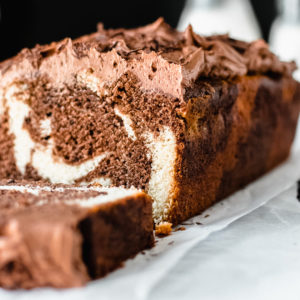 close up of chocolate marble load cake with chocolate frosting