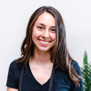 woman with brown hair wearing a black shirt smiling