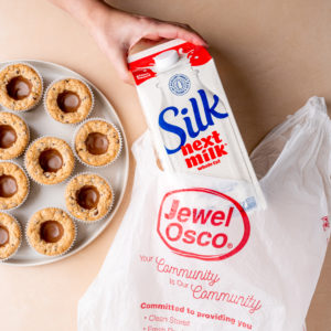five albertsons silk cookies on a plate next to a cartoon of silk milk in a bag