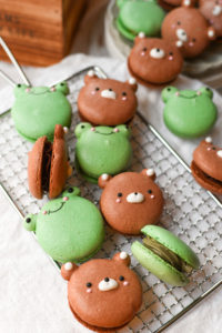 green and brown bear and frog macaroons on a rack