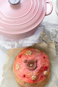 bread with pink frosting, flowers, and bears next to a pink pot