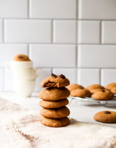 stack of five chocolate chip cookies on a white tablecloth