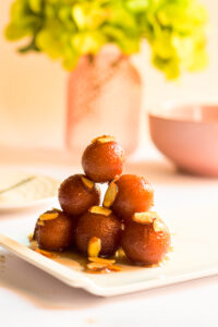 stack of five desert balls with toppings on a white plate