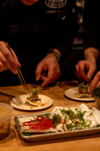 person holding chopsticks with a plate of food