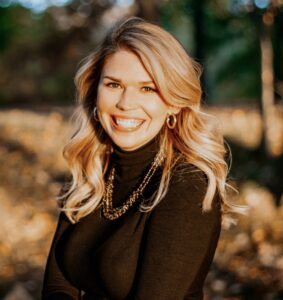 woman in turtleneck with blond hair smiling