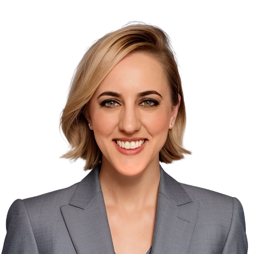 a woman with short blonde hair wearing a gray blazer smiles in front of a white background